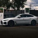 A modern electric car charging at a public EV station, showcasing a sleek design with a focus on sustainability and green technology. The vehicle is powered by clean energy, highlighting the future of transportation